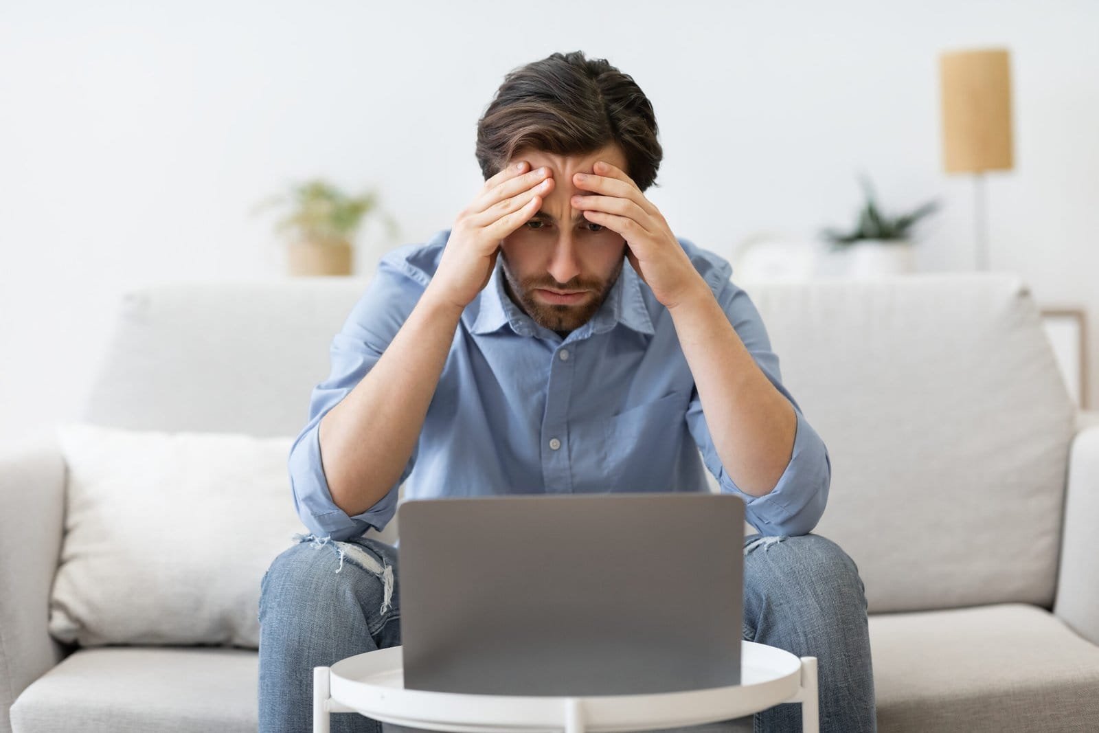 businessman at laptop touching head having busines 2023 11 27 05 23 47 utc scaled