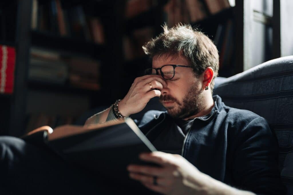 A man with sore eyes due to long work hours looks to Melatonin as a lessor known solution for eye health