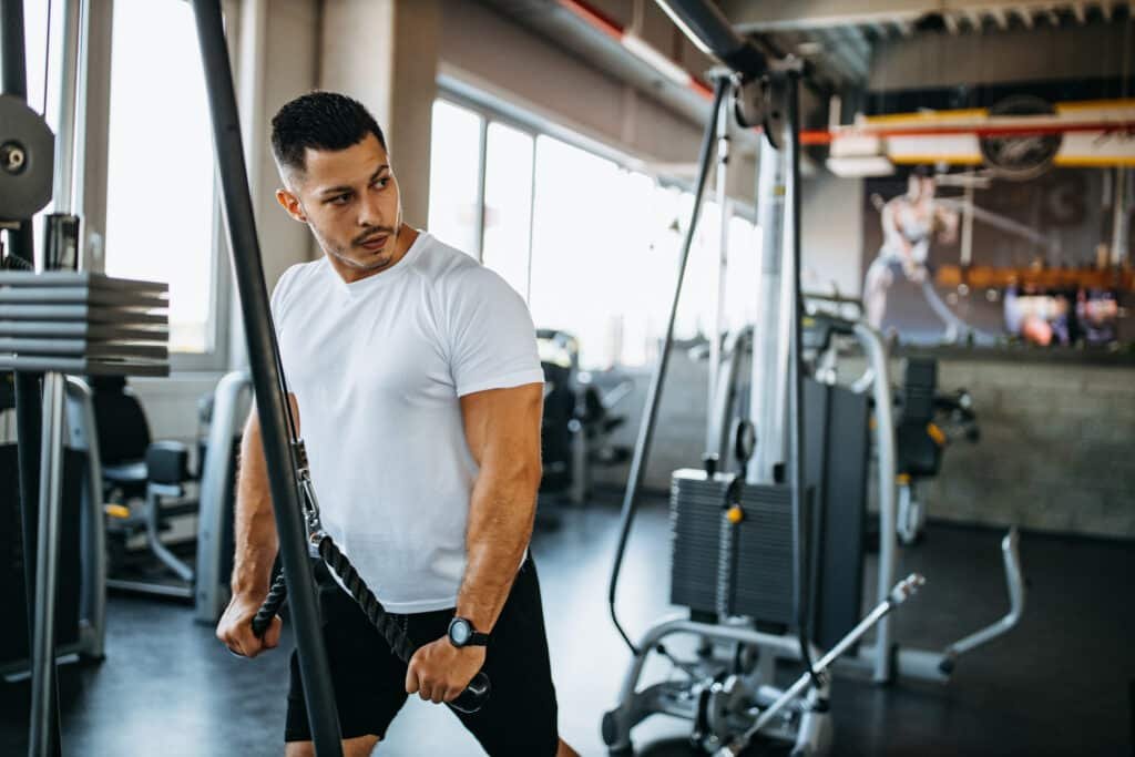 Which Ashwagandha is Best for Muscle Growth? Expert Guide to Top 5 Science-Backed Options 9 Man doing tricep workout at gym with pull downs is amplifying his Gains with KSM-66 Ashwagandha