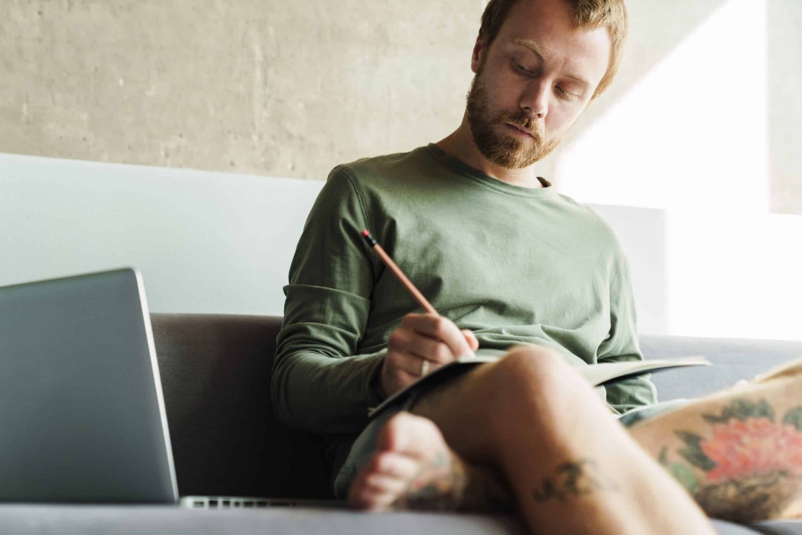 Healthy Ways to Reduce Stress | Man Drawing on Couch and listening to his favorite music.