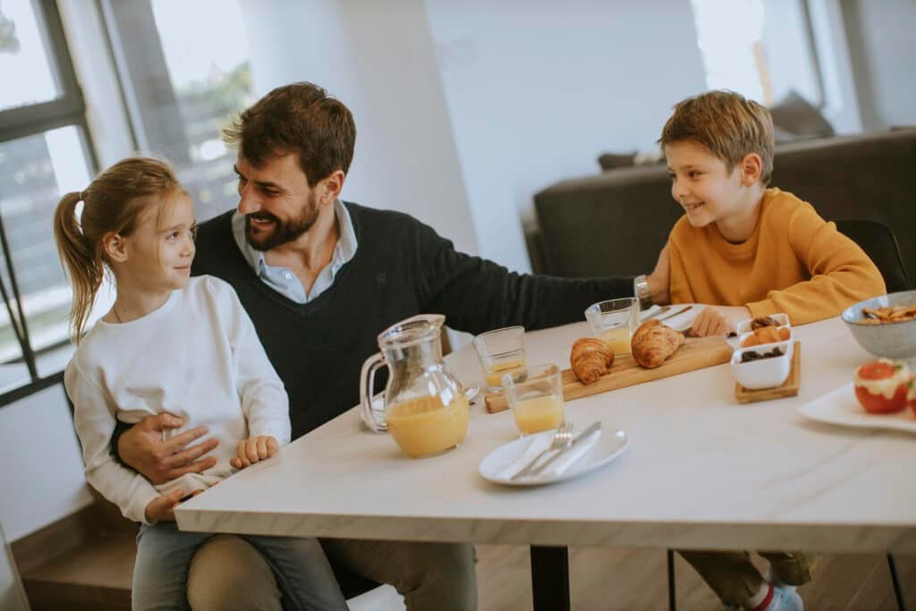 Good Sleep Health: A Dad’s Guide to Staying Sharp, Calm, and Healthy 3 Dad having breakfast with son and daughter after having good sleep health and waking up refreshed.