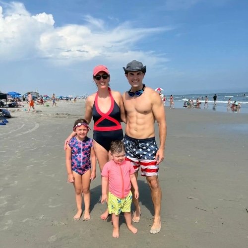 A man taking a selfie with his do in an open field. It's fall and cool outside.